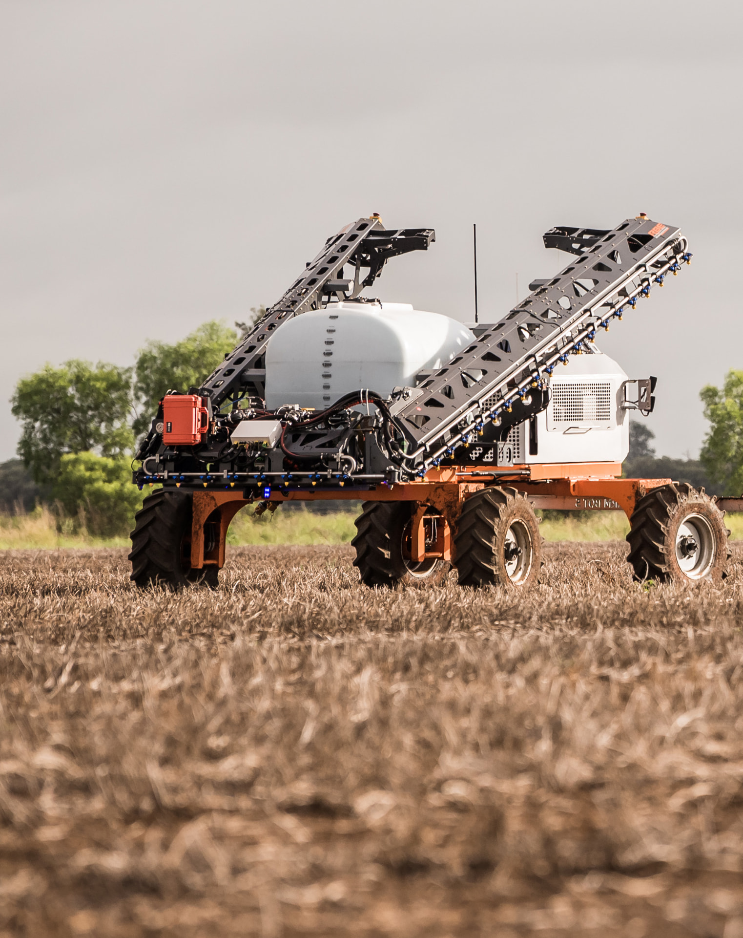 SwarmBot sprayer standing in a green paddock under blue sky